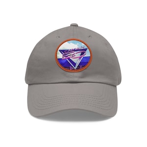 May include: A grey baseball cap with a colourful patch featuring the text "CAPTAIN EO" in a retro 80s style.