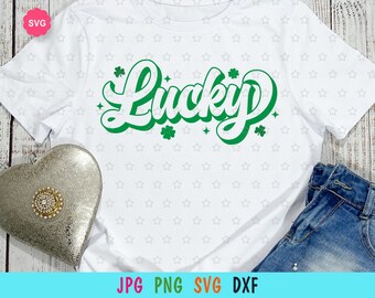 May include: White t-shirt with a green "Lucky" graphic in a retro font. The graphic is surrounded by shamrock designs. The shirt is on a white background with a white star pattern.