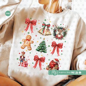 Puede incluir: Una sudadera blanca con un diseño navideño. El diseño presenta un hombre de jengibre, un árbol de Navidad, un reno, un cascanueces, un lazo y campanas. El diseño está en estilo acuarela y está rodeado de estrellas rojas y verdes.