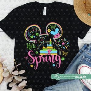May include: Black t-shirt with a colorful Mickey Mouse head design. The design includes a castle, fireworks, and the text "Hello Spring".