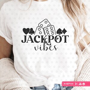 May include: White t-shirt with a black graphic design of dice, playing cards, and the text "JACKPOT vibes".