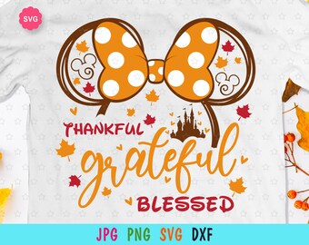 May include: A white t-shirt with a brown and orange Minnie Mouse ears design with white polka dots. The text "Thankful grateful blessed" is written in brown and orange with a brown castle graphic.