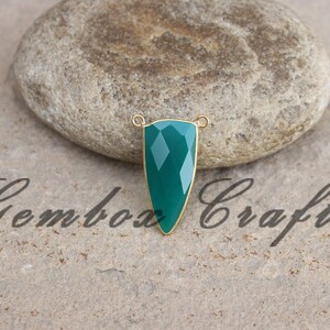 May include: A green gemstone pendant with gold-toned accents. The pendant is shaped like a teardrop and has a faceted design.