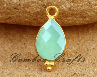 May include: Gold-plated pendant with a light blue teardrop-shaped gemstone. The pendant has a small loop at the top for attaching to a chain or cord.