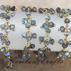 以下が含まれることがあります： 虹色の青いラブラドライトの宝石ビーズが付いた、金色のチェーンが4本。チェーンは小さく繊細なリンクで作られており、ビーズはファセットカットが施され、キラキラとした仕上がりになっています。