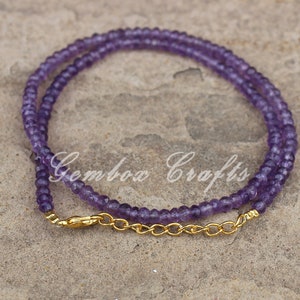 May include: A delicate amethyst gemstone necklace with a gold chain clasp. The necklace is made of small, round beads and is perfect for layering.