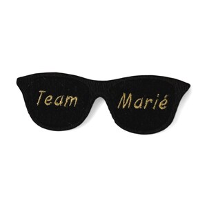 Peut inclure: Lunettes de soleil en feutre noir avec broderie dorée "Team Marie".