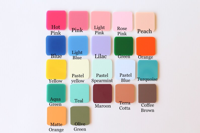 May include: A collection of square acrylic color swatches in various shades, including pink, blue, green, and orange. Each swatch is labeled with its color name, such as "Hot Pink," "Blue," and "Olive Green." The swatches are arranged on a white surface.