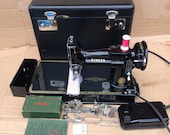 Vintage Singer 221K Featherweight Sewing Machine with attachments and instruction manual.