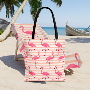 Op de afbeelding: Een roze-wit gestreepte tote bag met een flamingo-patroon. De tas heeft zwarte handvatten en is gemaakt van canvas.