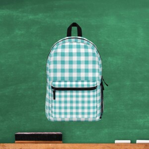 May include: A turquoise and white checkered backpack. The backpack has a zippered pocket on the front.