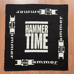 May include: Black square bandana with the words "HAMMER TIME" in large white block letters in the center. The words "MC Hammer" are printed in white around the edges of the bandana.