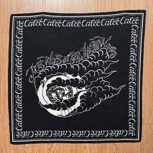 May include: Black square bandana with white graphic design. The design features a swirling cloud-like shape with a central circular element and the text "My Ways of the Ways". The border repeats the word "Calee".