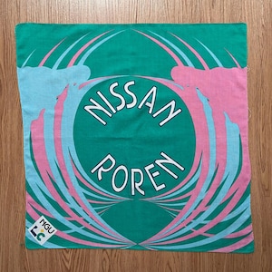 Könnte beinhalten: Ein grünes Bandana mit einem weißen Kreis in der Mitte. Der Kreis enthält die Wörter "NISSAN" und "POREN" in weiß. Das Bandana hat ein pink-blaues Spiralmuster.