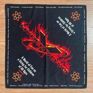 May include: Black bandana featuring a red and orange yo-yo graphic with the text "HYPER YO-YO" and "A World of Fun on a String for Children of All Ages." Includes atomic symbols and yo-yo tricks.