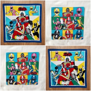 Puede incluir: Cuatro cuadrados de tela coloridos con un tema de superhéroes. Cada cuadrado presenta un grupo diferente de personajes en varias poses. Los cuadrados están todos bordeados de azul y tienen el texto "Super Sentai" en caracteres japoneses.