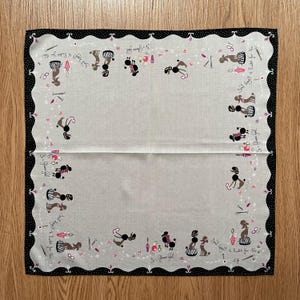May include: A white cotton handkerchief with a black polka dot border. The handkerchief features a repeating pattern of black poodles with pink bows and the text "It's a Poodle Thing, You Wouldn't Understand."