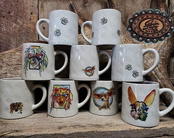 May include: A collection of ten white ceramic mugs with various hand-painted designs featuring dogs. Some mugs have paw prints, while others have colorful illustrations of dogs with unique expressions.