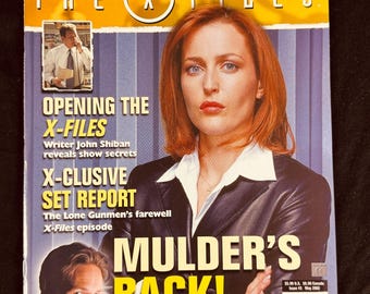 May include: A magazine cover for The X-Files featuring a large portrait of a woman with red hair wearing a dark blazer. The text reads "Mulder's Back!", "Opening the X-Files", and "X-clusive Set Report". A smaller image of a man in a suit is included.