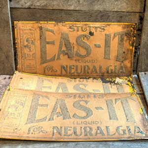 May include: Three vintage yellow and brown metal signs advertising "Stutts Eas-It (Liquid) for Neuralgia".