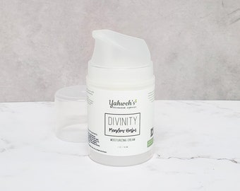 Könnte beinhalten: Eine weiße Plastikflasche mit einem Pumpspender. Die Flasche ist mit "Yahweh's Holistic Organics Divinity Meadow Balm Moisturizing Cream 1 oz / 28 ml" beschriftet.