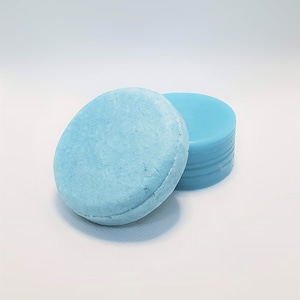 May include: Two light blue solid shampoo bars. One bar is stacked on top of the other.