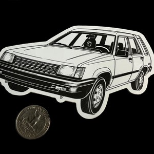 May include: Black and white line art illustration of a Toyota Tercel wagon. The car is facing forward and the front grill and headlights are visible. The car is on a black background.