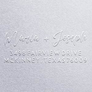 Könnte beinhalten: Ein weißes, geprägtes Rücksendeetikett mit den Namen "Maria + Joseph" und der Adresse "3498 Fairview Drive, McKinney, Texas 76009".