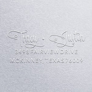 May include: A white embossed return address label with the names "Tracy + Justin" and the address "3498 Fairview Drive, McKinney, Texas 76009".