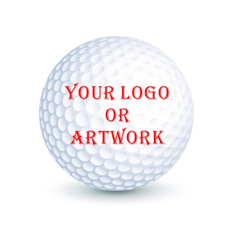 K&ouml;nnte beinhalten: Ein wei&szlig;er Golfball mit dem Text "YOUR LOGO OR ARTWORK" in Rot.