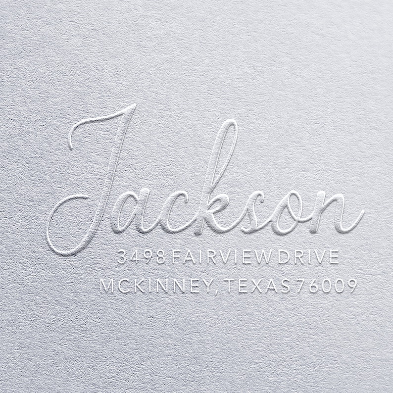 K&ouml;nnte beinhalten: Wei&szlig;e Pr&auml;gung auf grauem Hintergrund. Der Name "Jackson" ist in Kursivschrift geschrieben. Unter dem Namen befindet sich die Adresse "3498 Fairview Drive, McKinney, Texas 76009".