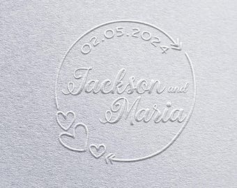 May include: White embossed circle with the date 02.05.2024, the names Jackson and Maria, and two hearts.