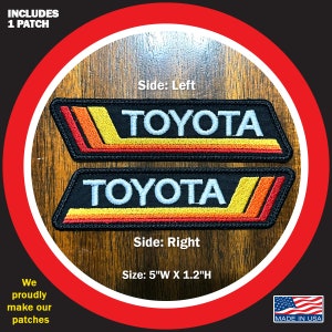 May include: Two embroidered patches with the word "TOYOTA" in white lettering on a black background. The patches have a red, orange, and yellow stripe design. The patches are 5 inches wide and 1.2 inches high. The text "INCLUDES 1 PATCH" is at the top of the image. The text "Side: Left" and "Side: Right" are below the patches. The text "Size: 5"W X 1.2"H" is at the bottom of the image. The text "MADE IN USA" is in the bottom right corner of the image.