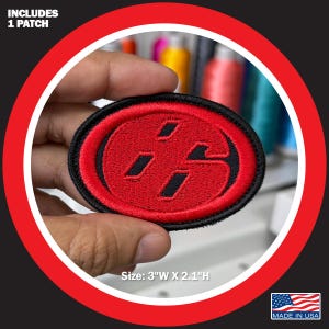 May include: Oval-shaped embroidered patch with a red design on a black background. The patch features a stylized "86" logo. The patch measures 3 inches wide and 2.1 inches high. The text "INCLUDES 1 PATCH" is at the top. The text "MADE IN USA" is at the bottom.