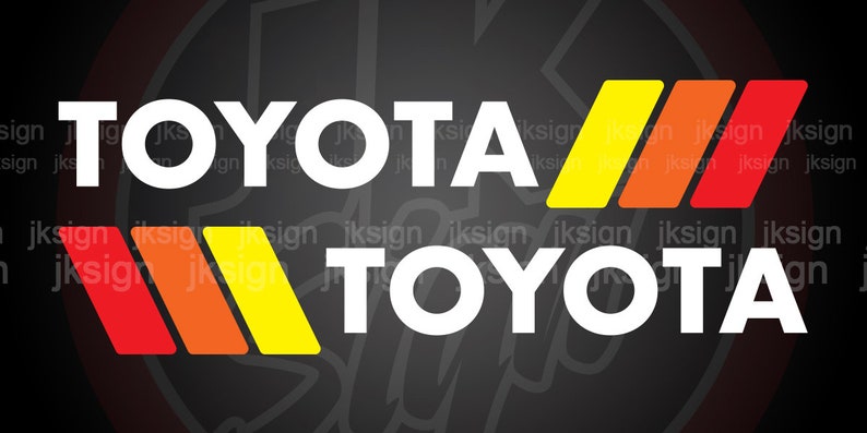 Op de afbeelding: Een wit Toyota-logo met de tekst "TOYOTA" in hoofdletters, met drie rode, oranje en gele strepen boven en onder de tekst.