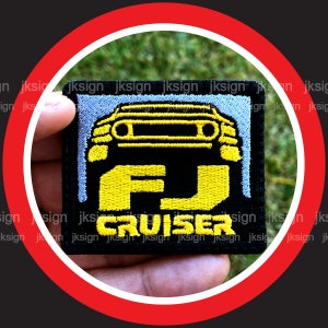 May include: A black and yellow embroidered patch with the text "FJ CRUISER" and a stylized image of a car.