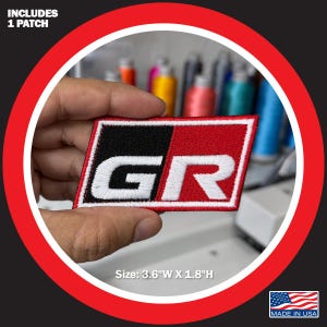 May include: A rectangular patch with the letters "GR" in white, set against a red and black background. The patch measures 3.6 inches wide and 1.8 inches high. The text "INCLUDES 1 PATCH" is at the top. The patch is made in the USA.