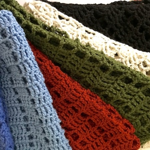 May include: Five crocheted scarves in different colors, including blue, light blue, red, green, and white. The scarves are made with a lacy stitch pattern.