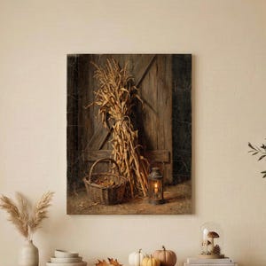 May include: A rectangular wall art print featuring a rustic wooden door background with a bundle of dried corn stalks, a woven wicker basket, and a small lit lantern. The color palette consists of warm brown, golden yellow, and dark wood tones.