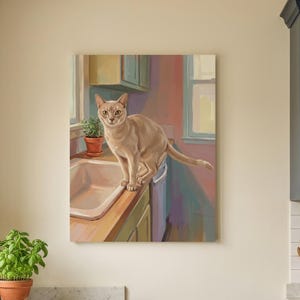 May include: A rectangular wall art print featuring a painting of a light tan cat standing on a kitchen sink counter. The artwork depicts a domestic scene with soft brushstrokes, warm lighting, and a cat looking directly forward in a kitchen.