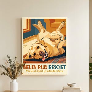May include: A rectangular wall art print featuring a yellow Labrador retriever lying on its back with its tongue out. The text reads BELLY RUB RESORT and The locals insist on extended stays. The illustration uses warm tones of yellow, orange, and blue.