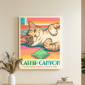 K&ouml;nnte beinhalten: Ein rechteckiger Wandkunstdruck mit einer Cartoon-getigerten Katze, die auf dem R&uuml;cken liegt und mit einem gr&uuml;nen Spielzeug spielt. Der Text lautet CATNIP CANYON und VISITORS REPORT LOSING ALL TRACK OF TIME. Der Hintergrund ist eine stilisierte Landschaft.