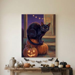 May include: A rectangular wall art print featuring a black cat sitting on a stack of orange pumpkins, including one carved jack-o'-lantern. The scene is set on a porch at dusk with string lights in the background and a purple sky.