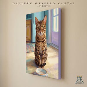 May include: A gallery wrapped canvas with a 1.5 inch depth featuring a digital painting of a brown spotted tabby cat sitting on a floor in front of a food bowl. The cat faces forward with green eyes, positioned near a doorway and kitchen cabinets.