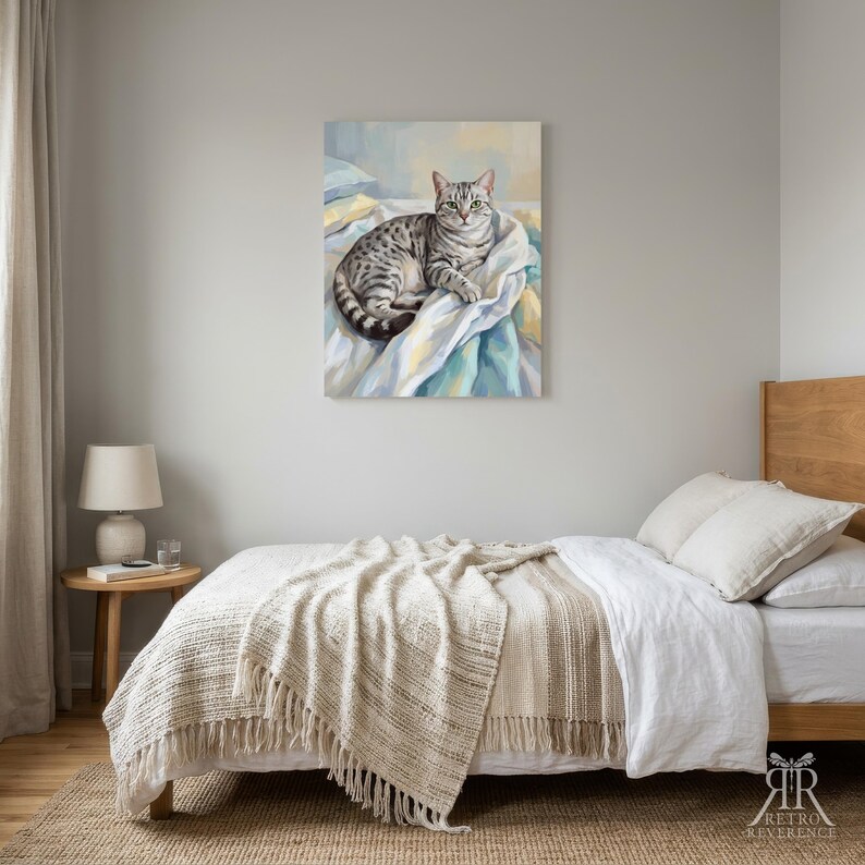 May include: A rectangular wall art print featuring a painting of a grey tabby cat with green eyes resting on white and blue rumpled fabric. The cat is positioned in the center of the canvas, which is displayed above a bed in a bedroom setting.
