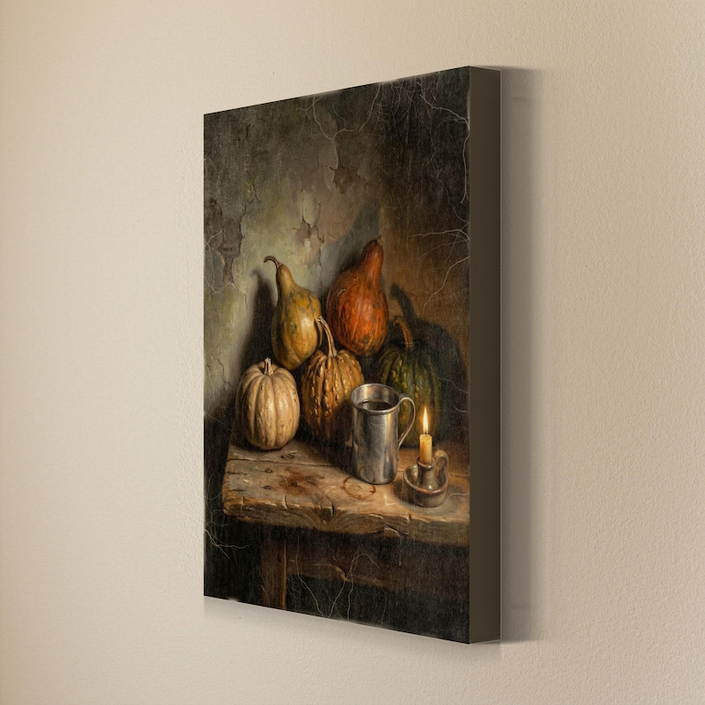 May include: A canvas print featuring a still life painting of several gourds and pumpkins arranged on a weathered wooden table. A metallic mug and a small lit candle in a holder sit beside the produce against a textured, dark, cracked wall.