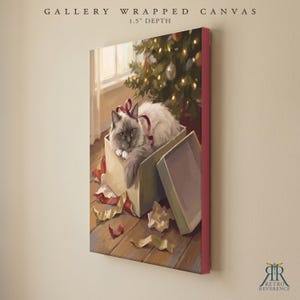 May include: A gallery wrapped canvas with a 1.5 inch depth featuring a painting of a fluffy white cat with dark points sitting inside an open gift box. The cat has a red ribbon draped over its head. A Christmas tree with lights is in the background.