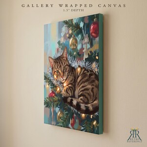 May include: A gallery wrapped canvas with a 1.5 inch depth featuring a painting of a brown tabby cat resting in a Christmas tree. The cat is surrounded by silver tinsel, glowing string lights, and red and gold ornaments against green pine branches.
