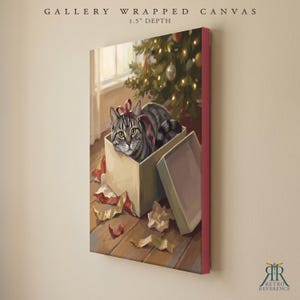 May include: A gallery wrapped canvas with a 1.5 inch depth featuring a painting of a grey tabby cat sitting inside a cardboard box with a red ribbon. The scene includes scattered wrapping paper on a wooden floor near a lit Christmas tree.