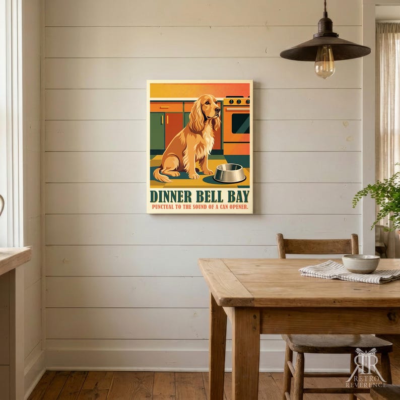 May include: A rectangular wall art print featuring a golden-colored dog sitting in a kitchen in front of a stove and a metal bowl. The text reads DINNER BELL BAY and Punctual to the sound of a can opener in dark green and red lettering.
